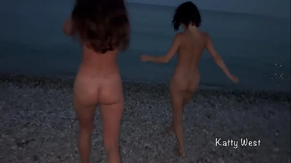 Two naked sluts play with each other in the sea on a public beach